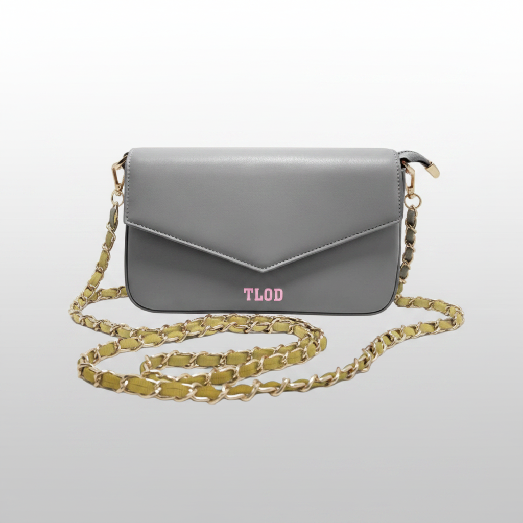 Gray handbag with a gold chain strap on a light gray background